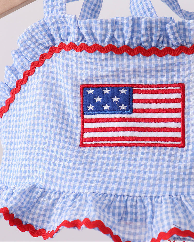 Blue checkered dress with American flag patch on a white background