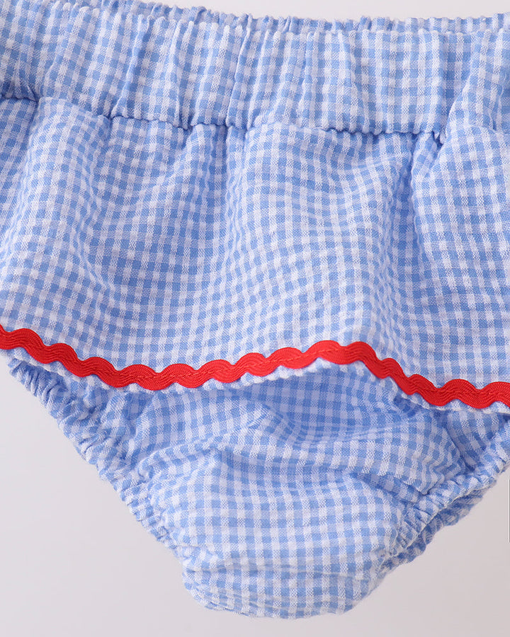 Blue checkered swim bottoms with red trim on a light gray background