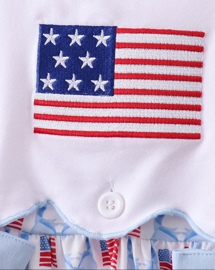 White dress with American flag design and button closure, featuring blue trim and small American flags on the inside.