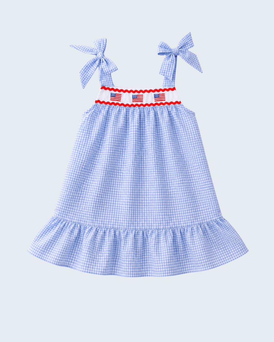 Blue checkered dress with bow straps on a light gray background