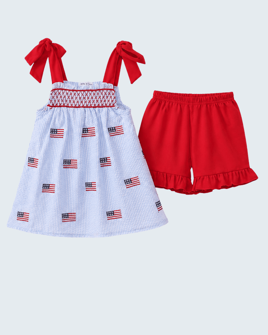 Children's outfit with a dress and shorts on a light gray background