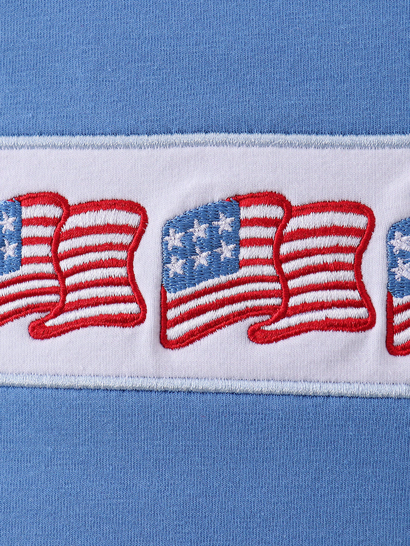 Close-up of a blue fabric with embroidered American flags.