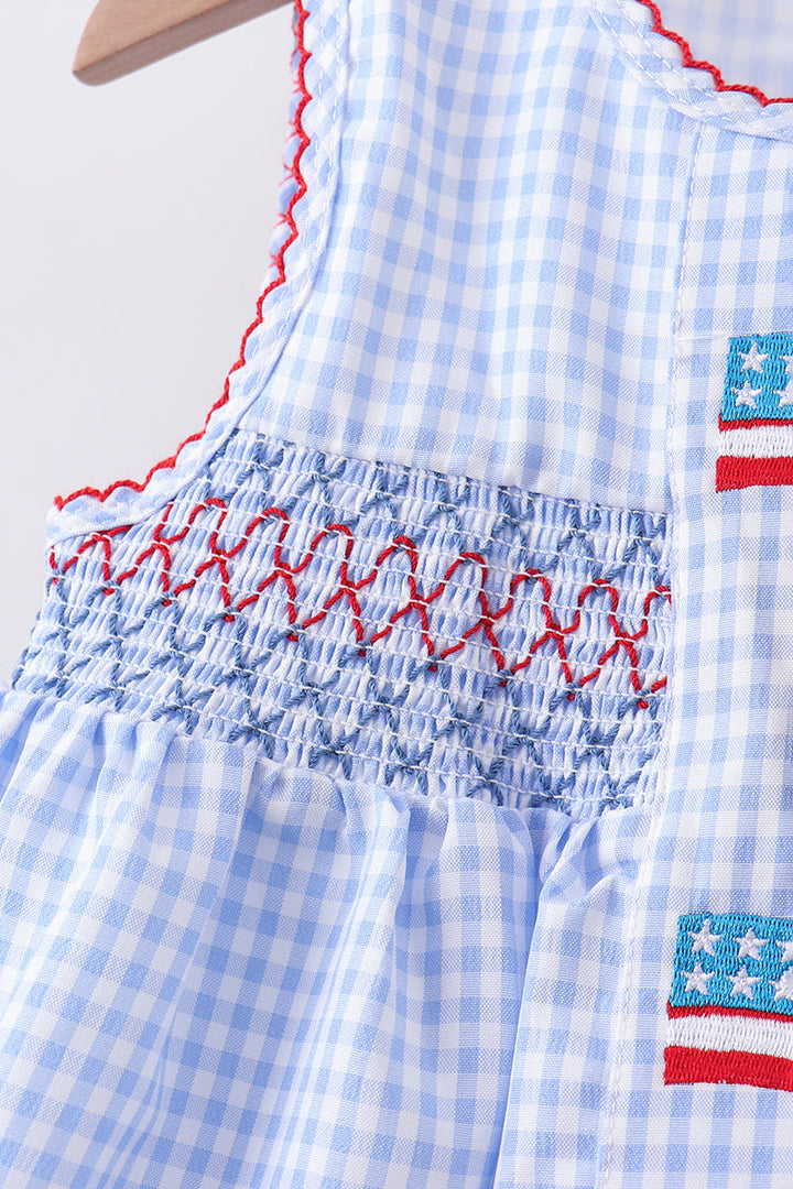 Blue checkered dress with red smocking and American flag patch on a white background