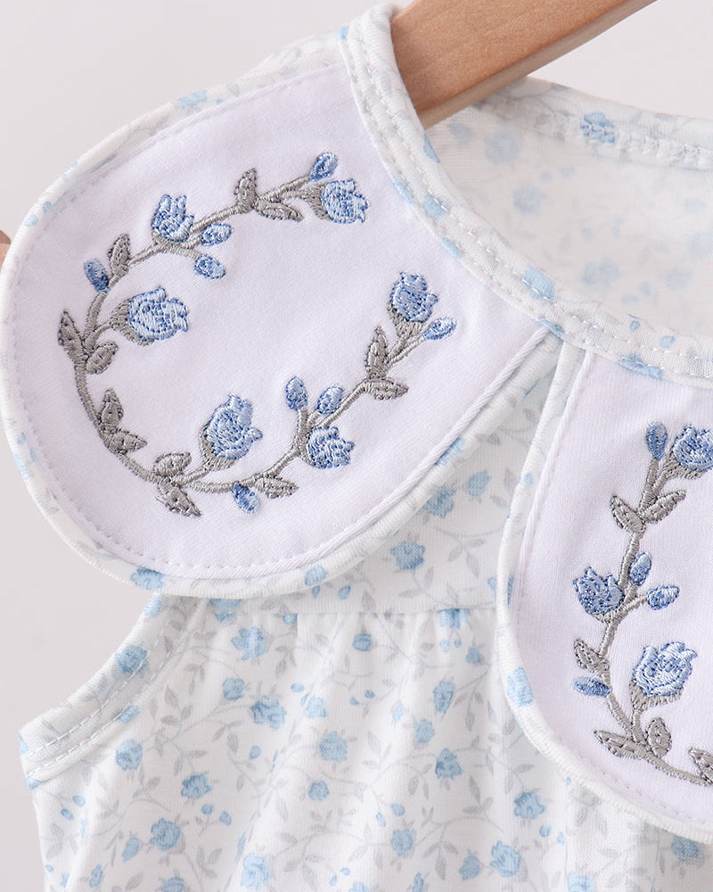 Dress with blue floral embroidery on a matching towel.