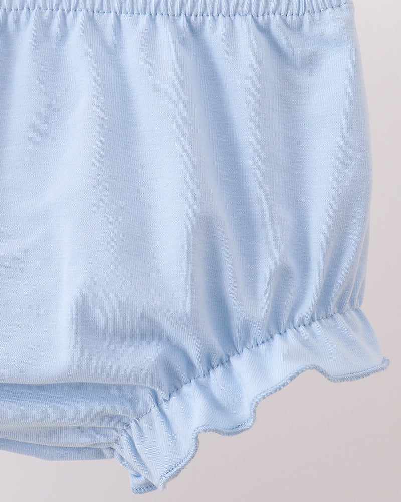 Light blue baby bloomers on a beige background