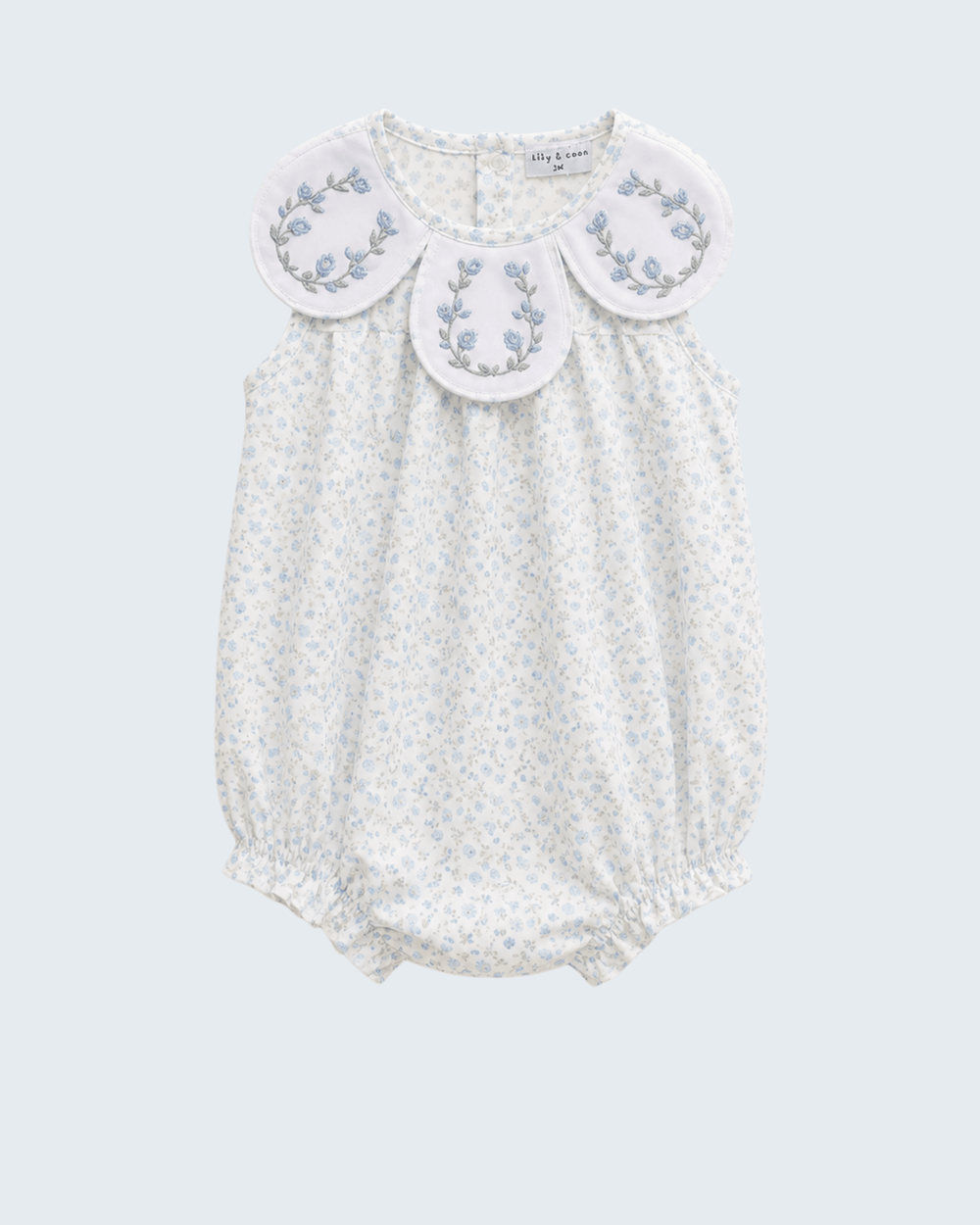 White baby romper with floral embroidery on a light gray background