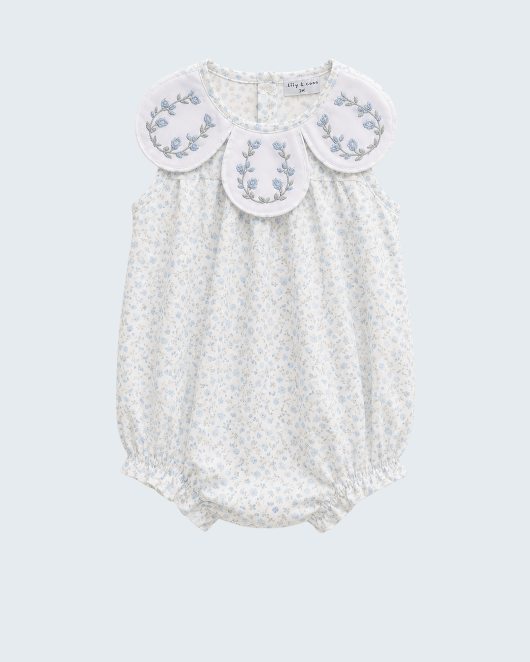 White baby romper with floral embroidery on a light gray background