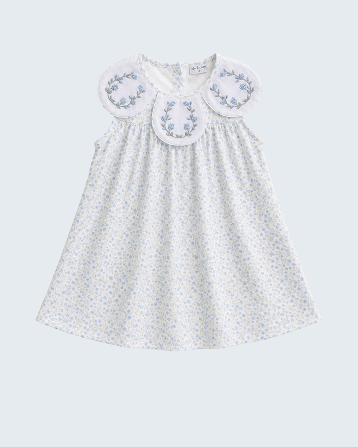 White dress with floral embroidery on a light gray background