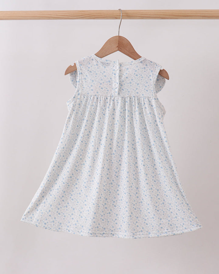 White dress with subtle pattern on a wooden hanger against a plain background