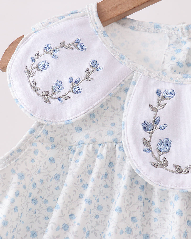 Floral embroidered dress with matching pouches on a white background