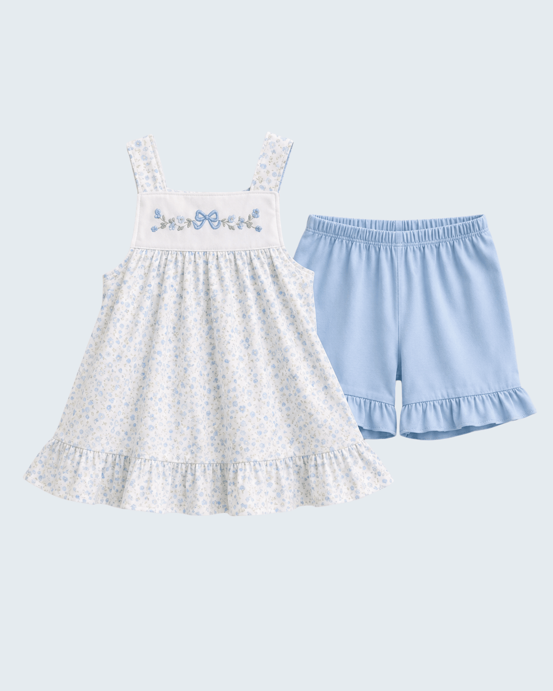 White dress with floral embroidery and blue shorts on a light gray background