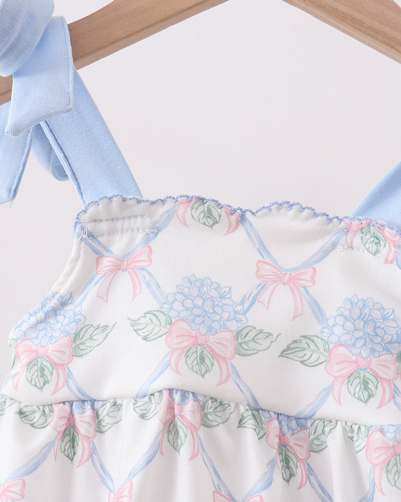 Baby romper with floral and bow pattern on a hanger