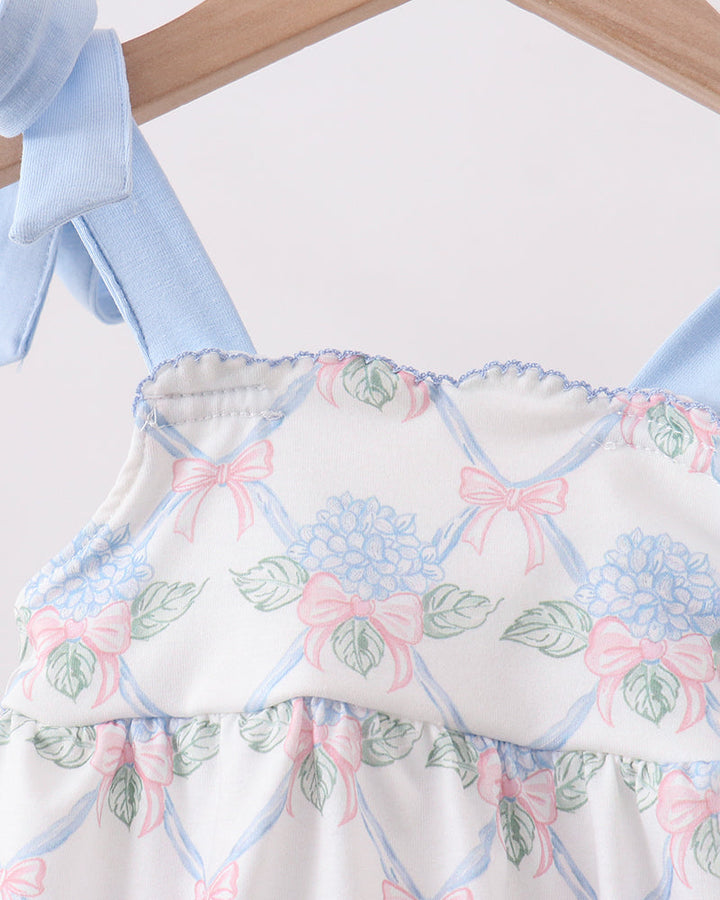 Baby romper with floral and bow pattern on a hanger