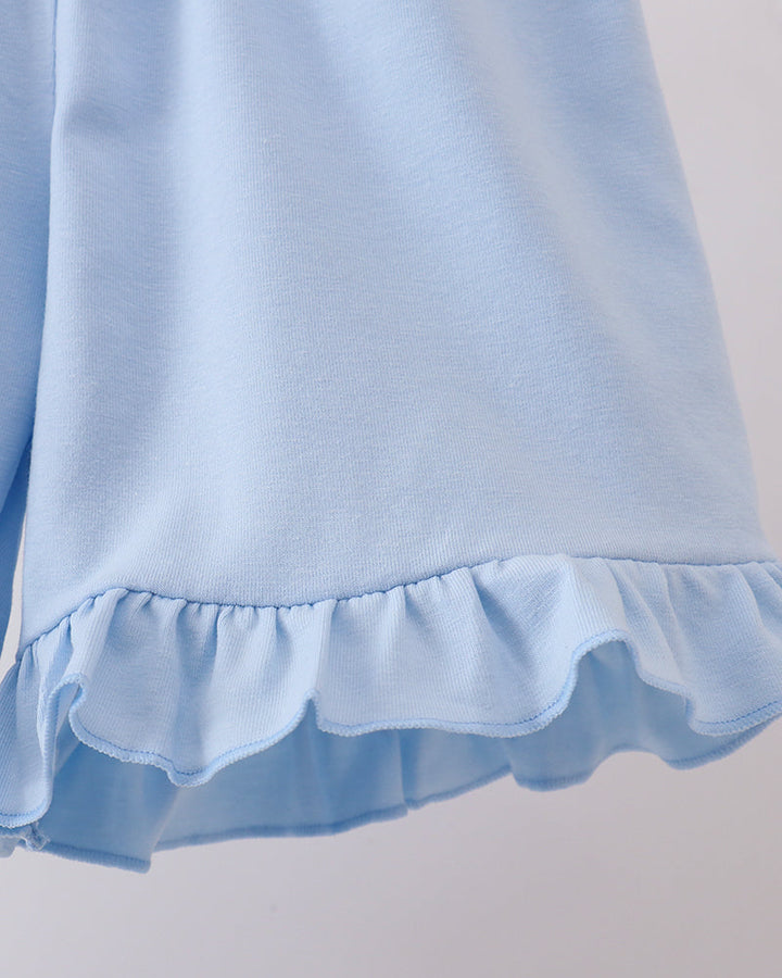 Light blue fabric with ruffled edge on a plain background