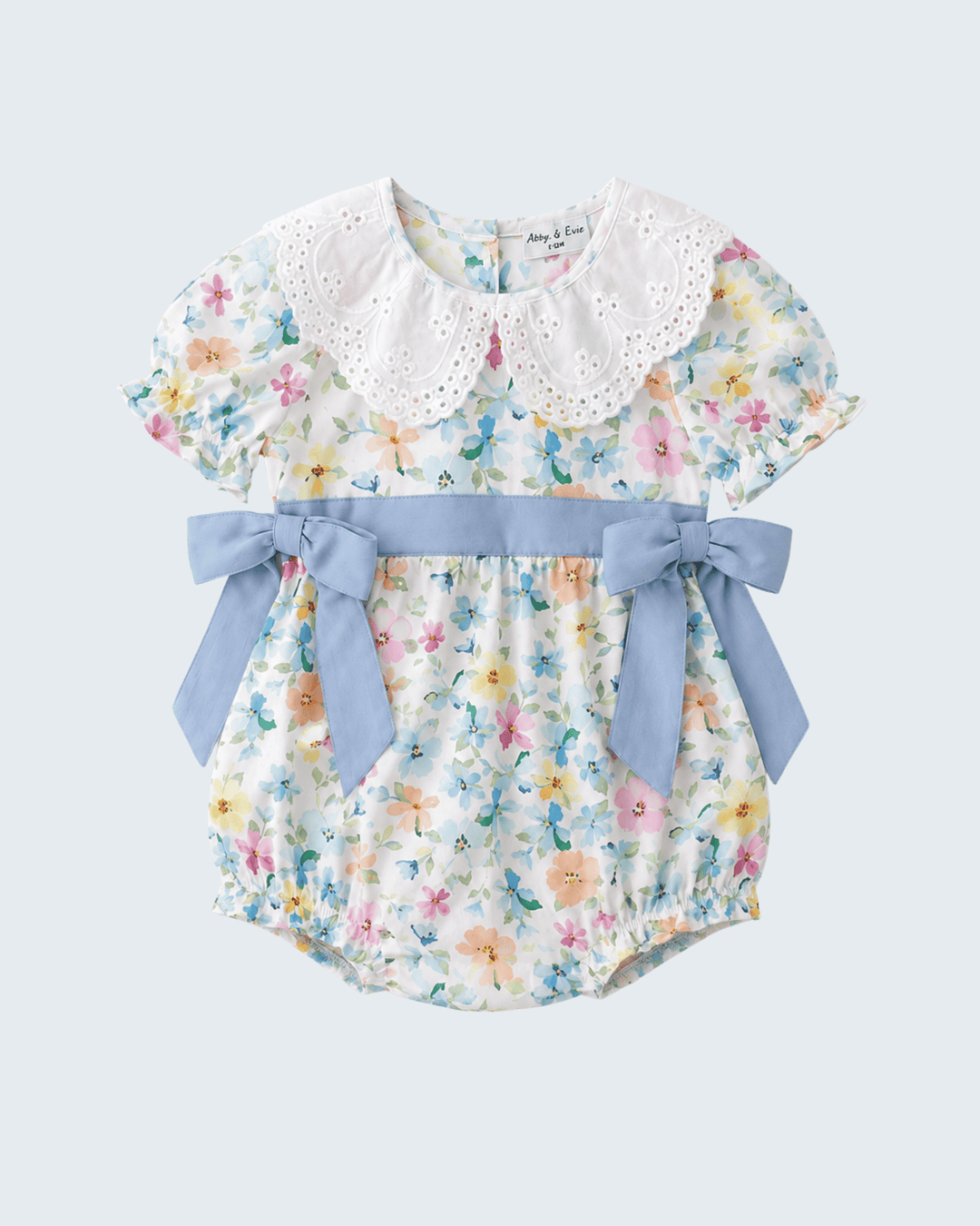 Floral baby romper with a blue bow on a light gray background