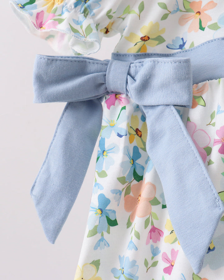 Floral dress with a large blue bow on a light gray background