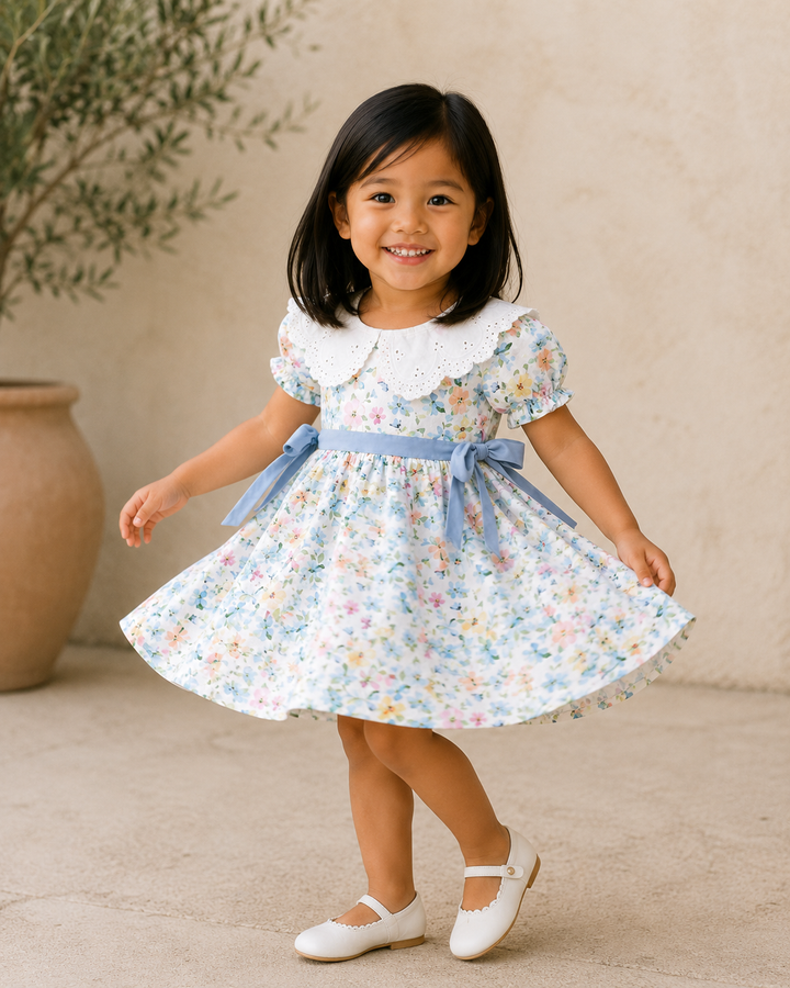 Young girl in a floral dress standing outdoors with a neutral background