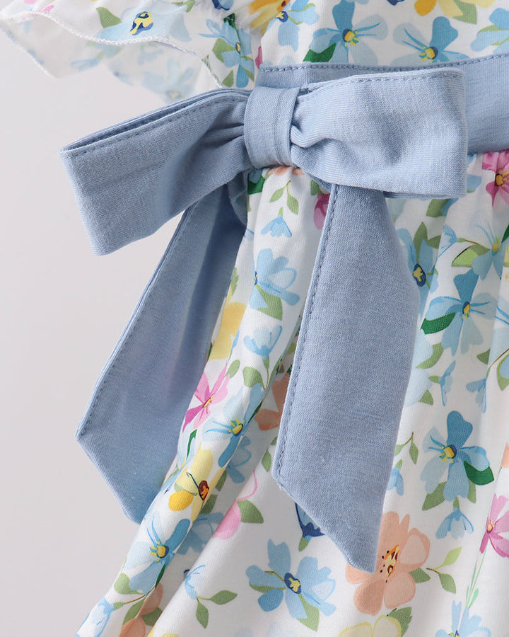Floral dress with a blue tie waist on a light background