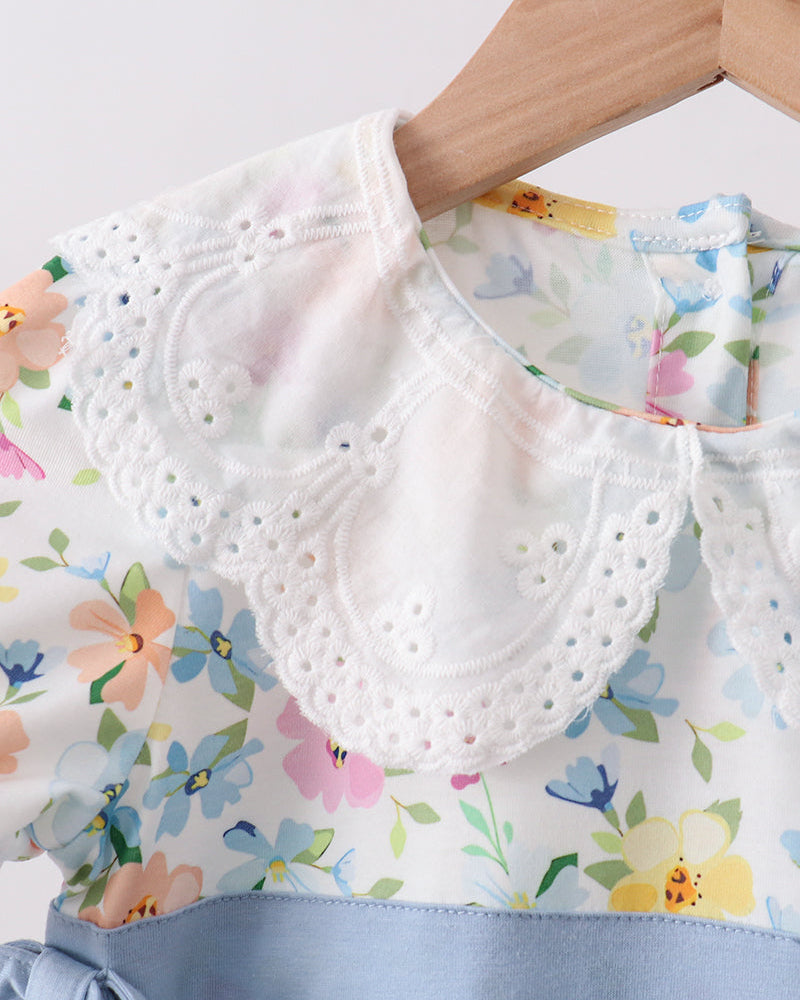 Floral dress with a white lace collar and blue ribbon waistband.