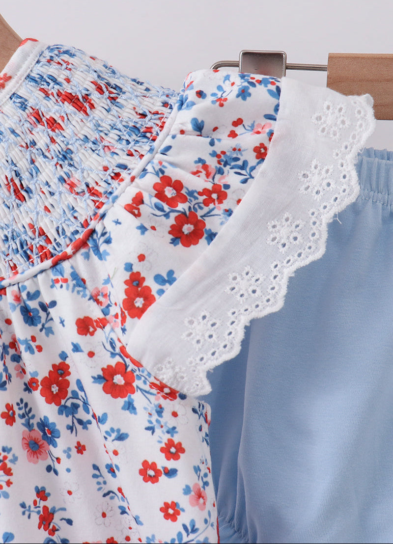 Floral patterned outfit with white lace trim on a light gray background
