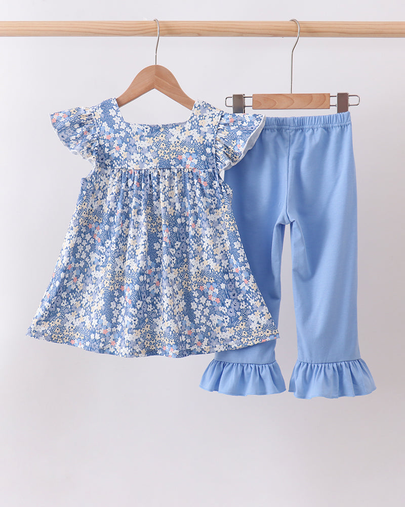 Blue floral ruffle top and light blue pants set on hangers