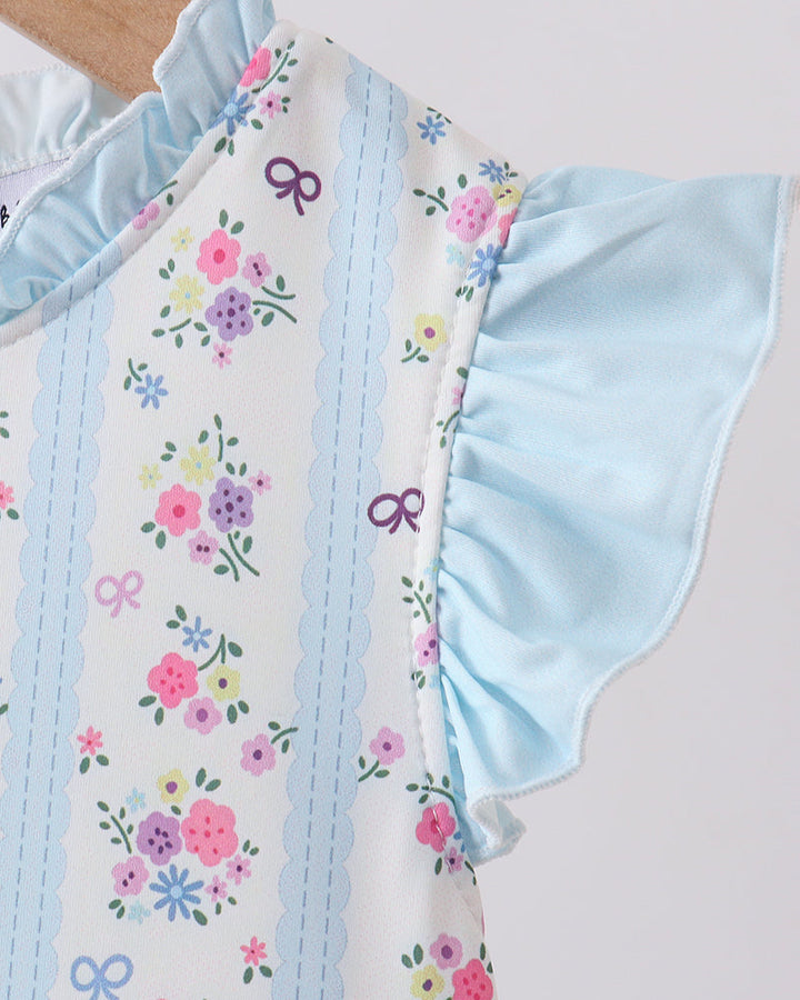 Swimsuit with floral pattern and ruffled details on a light background