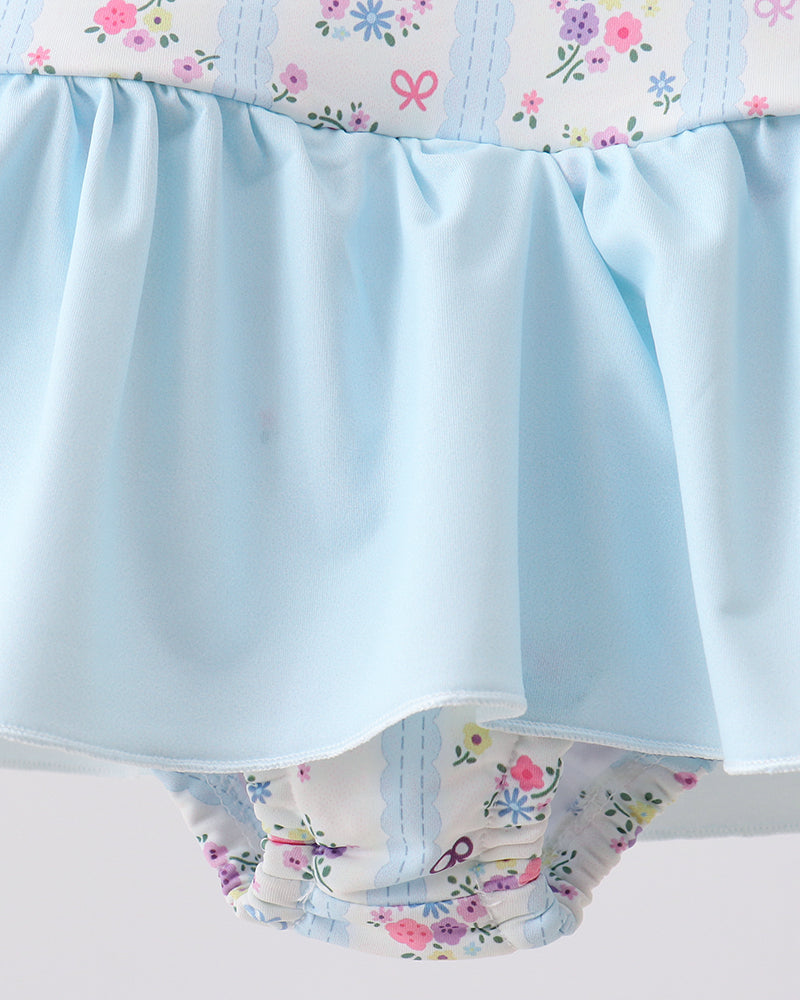 Floral-patterned swimsuit with a light blue waistband on a white background