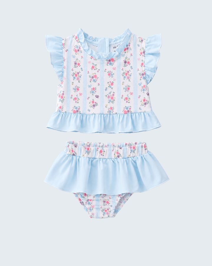 Two piece swimsuits in blue and white flowers on light grey background.