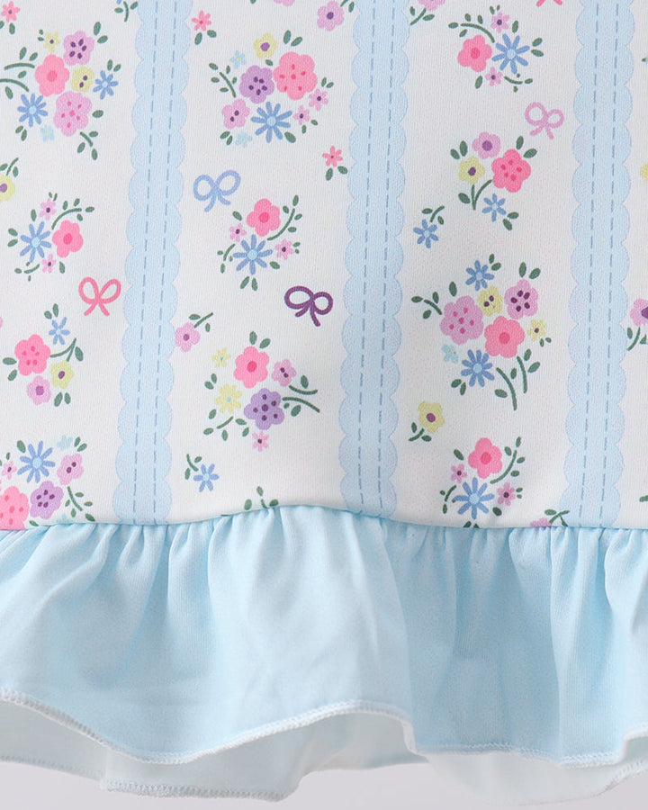 Floral and bow patterned fabric with a light blue ruffled edge on a white background