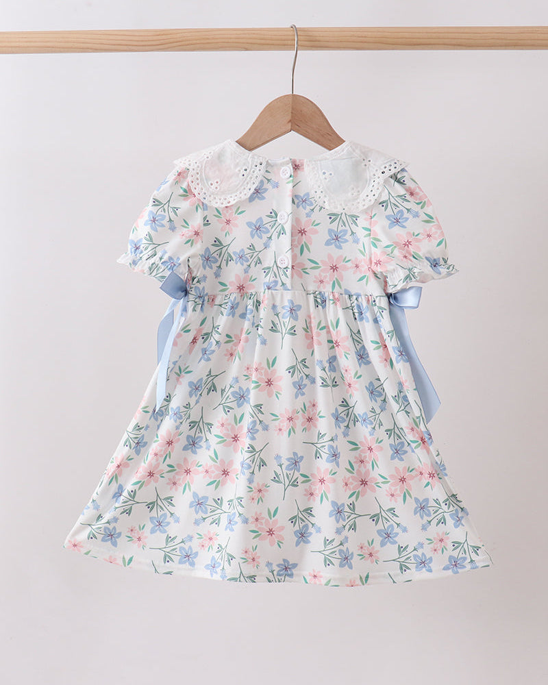 Floral dress on a hanger against a plain background