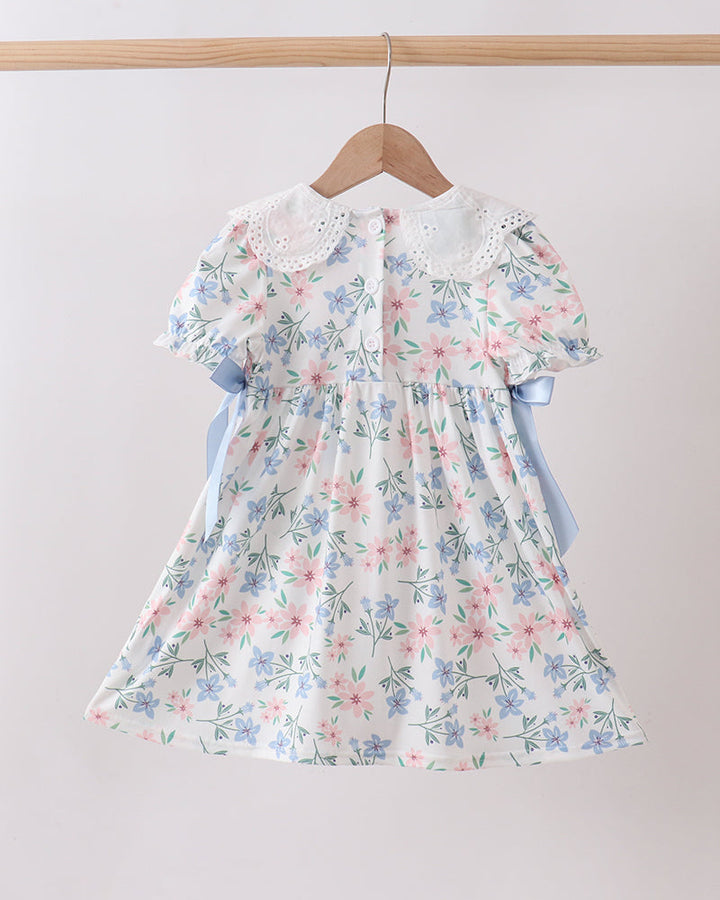 Floral dress on a hanger against a plain background