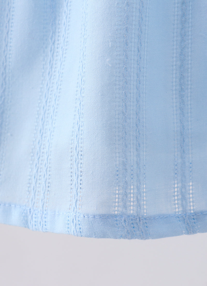 Close-up of a light blue fabric with textured pattern on a white background