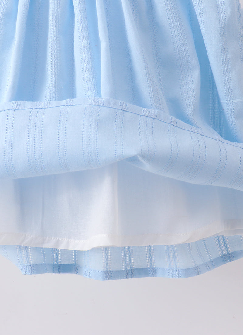 Close-up of light blue fabric with a subtle pattern on a white background