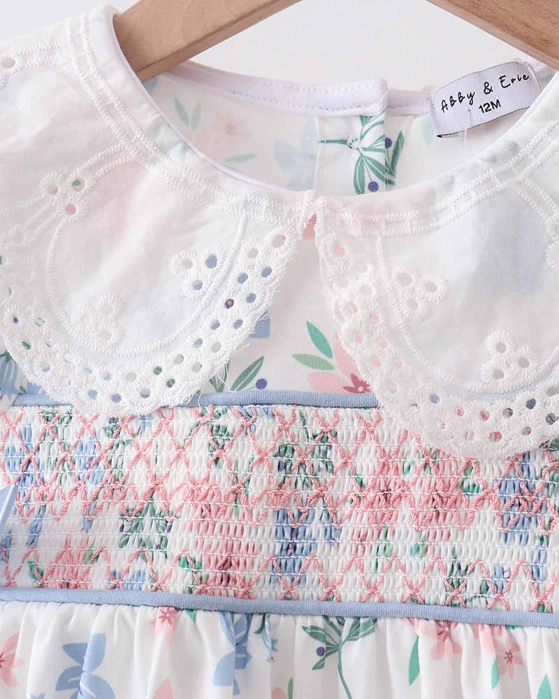 Floral dress with smocked details on a hanger, featuring the brand &