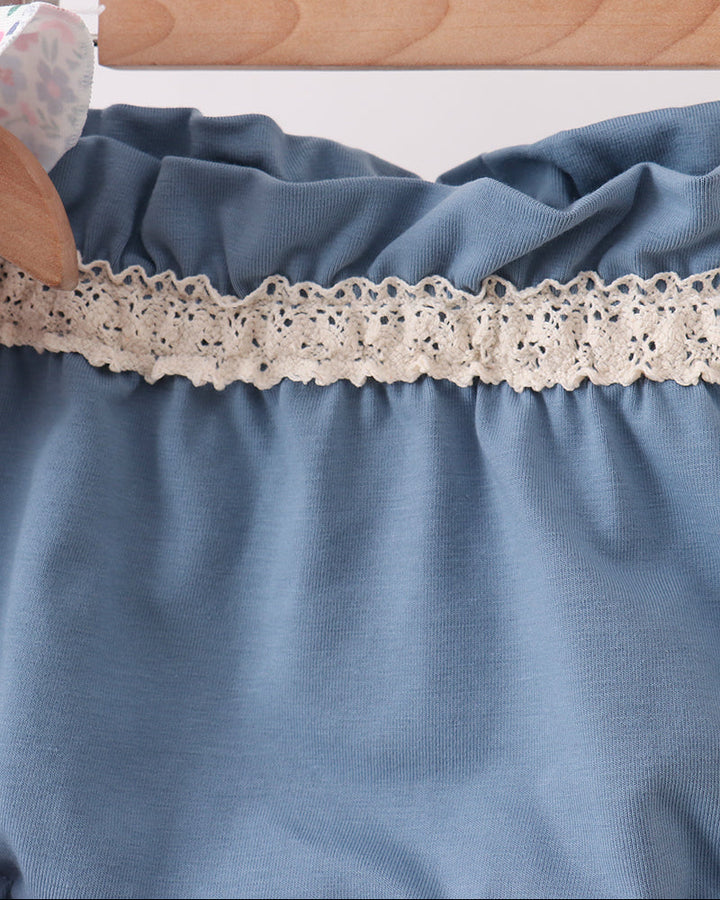 Blue fabric with lace trim on a wooden hanger against a white background
