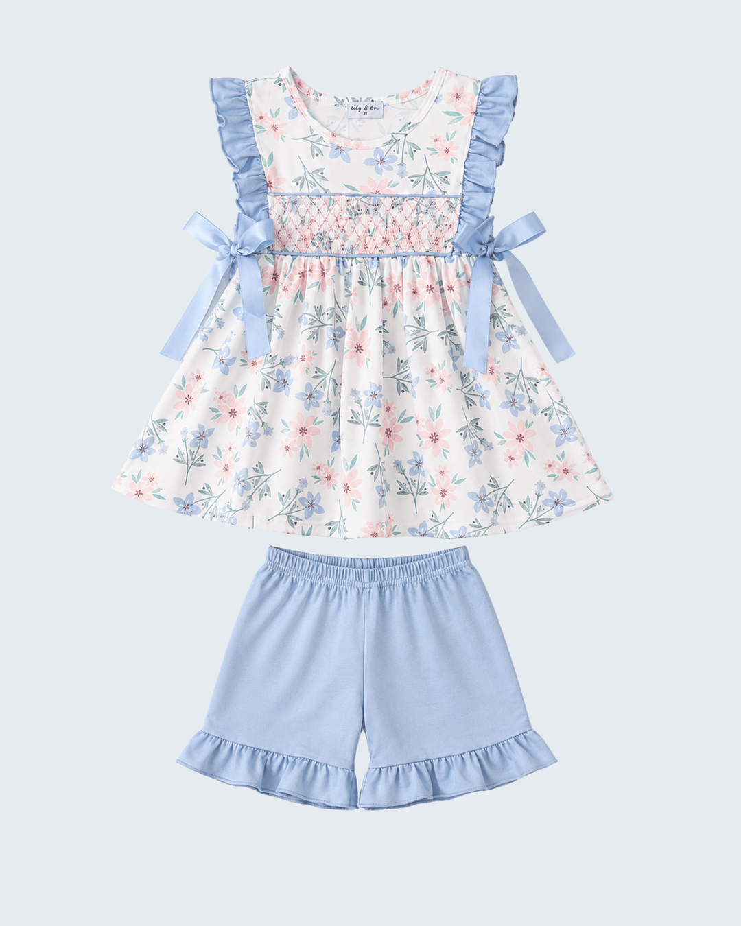 Floral dress with blue ruffles and matching shorts on a light blue background