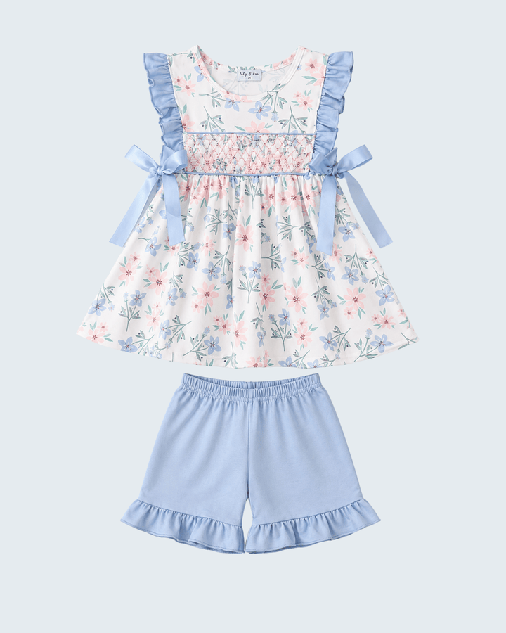 Floral dress with blue ruffles and matching shorts on a light blue background
