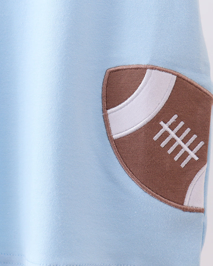 Light blue t-shirt with brown football applique on the sleeve cuff
