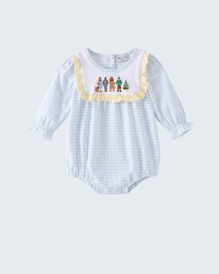 A baby long-sleeve romper in a light blue and white gingham pattern, featuring a white bib collar with a yellow ruffle trim and a colorful embroidered family motif. The romper has elasticated cuffs and a snap-button crotch.