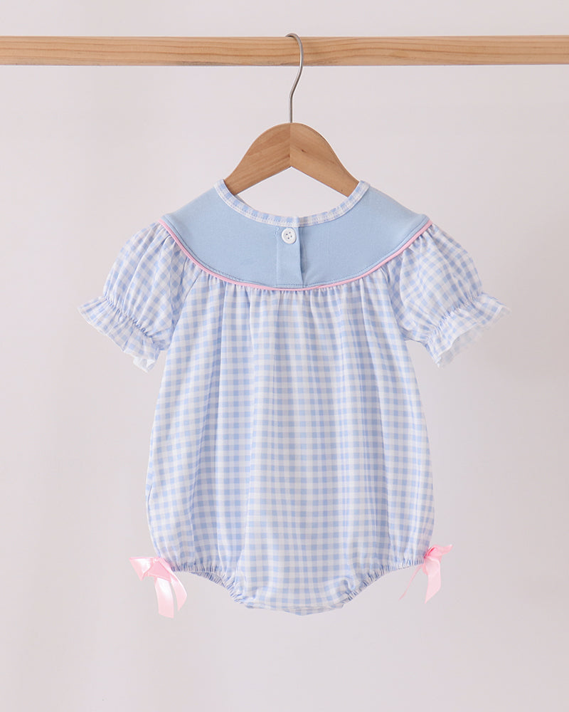 Blue gingham bubble romper with short flutter sleeves and pink side bows at legs.