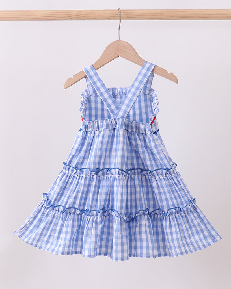 Blue checkered dress on a hanger against a white background