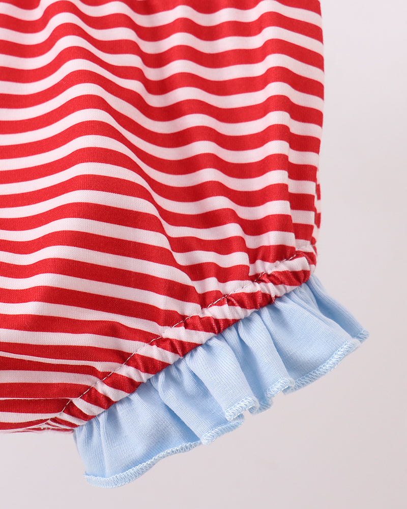 Red and white striped dress with a blue ruffled hem on a light gray background