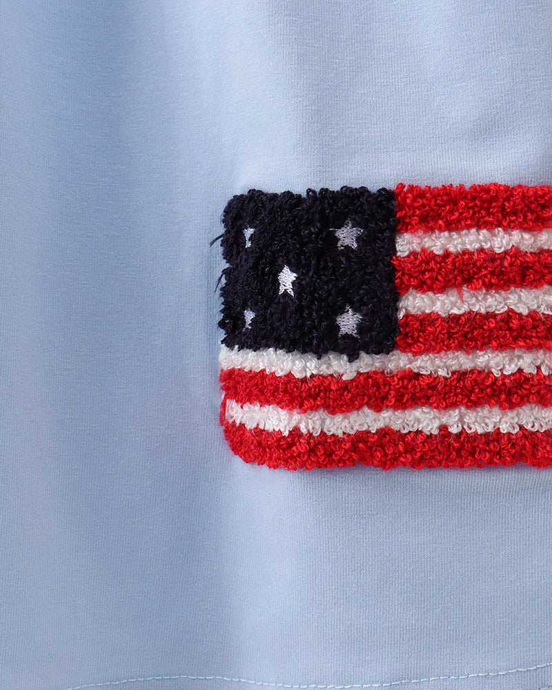 Close-up of a red, white, and blue flag patch on a light blue background