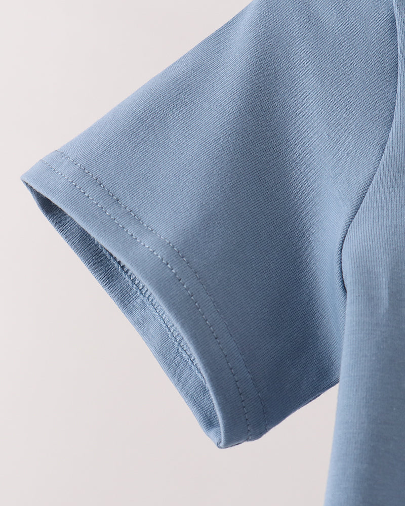 Close-up detail of a light blue short-sleeve t-shirt showing the sleeve cuff with neat stitching against a plain light background.