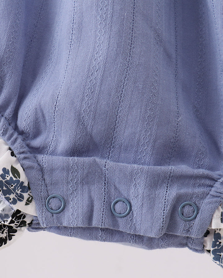 Light blue bubble romper with snap-button leg opening and gathered waist