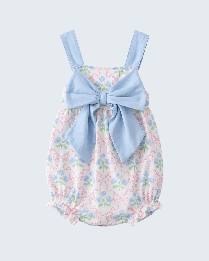 Floral baby romper with a large blue bow on a light gray background