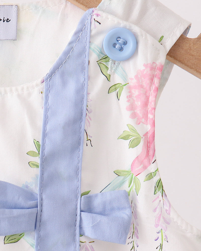Floral fabric with a blue button and ribbon on a matching floral background