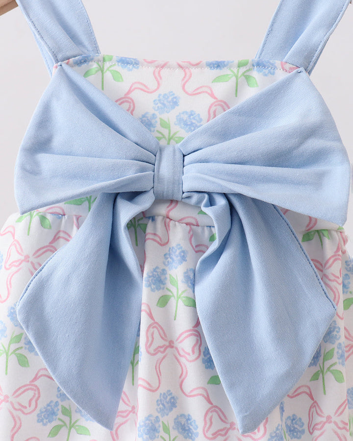 Light blue dress with a large bow on a floral background