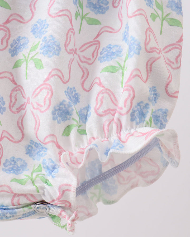 Baby romper with bow and floral pattern on a white background