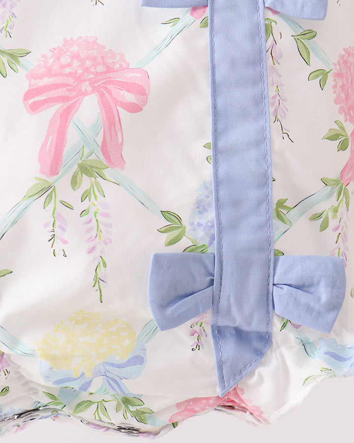 Floral-patterned fabric with a blue ribbon tied into a bow.